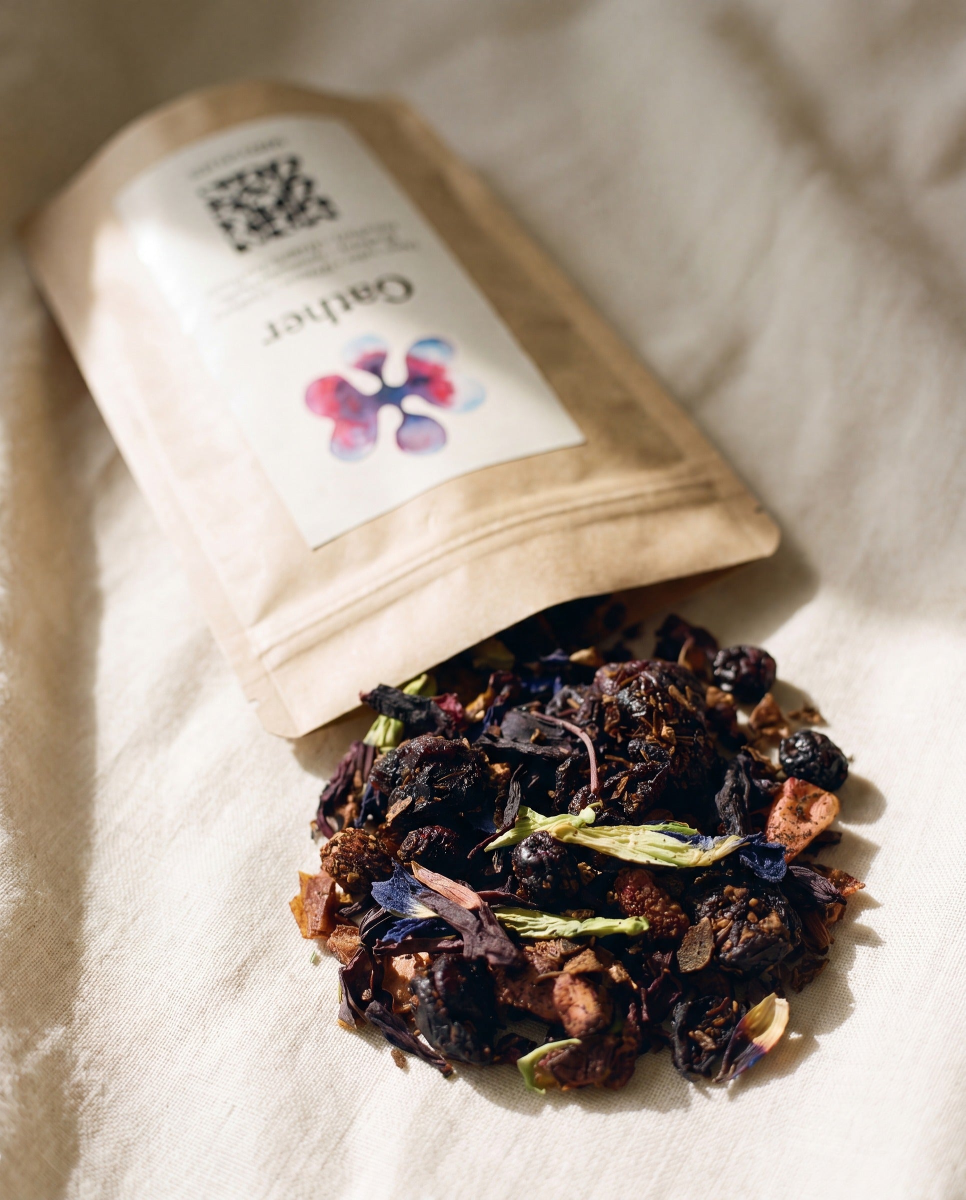 Menjunjes Gather pouch with loose-leaf tea spilling onto cream linen
