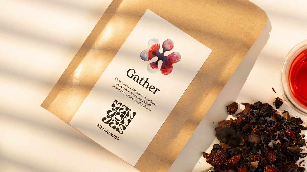 The front label of a Gather pouch, its seven ingredients listed under the name, beside the loose blend and a cup of the brewed tea